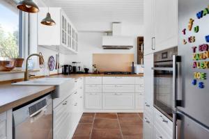 cocina blanca con fregadero y nevera en Fjordlyst en Holbæk