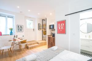 a bedroom with a bed and a table and a kitchen at Happy Stay Paris - Cosy Studios - 5 min to Eiffel Tower in Paris