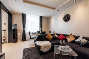 sala de estar con sofá y reloj en la pared en LuxeCityApartment, en Tallin
