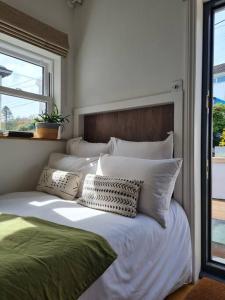 uma grande cama branca com almofadas e uma janela em THE ANNEX, Lostwithiel Small Double Bed, Private Parking, Quiet Location em Lostwithiel