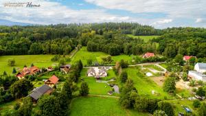 Letecký snímek ubytování Wonder Home - Apartamenty Czerwony Dworek - duży teren zielony, plac zabaw, miejsce na grilla i staw z możliwością wędkowania