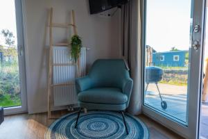 uma cadeira verde sentada num quarto ao lado de uma porta em Ferienhäuser Seepark Ternsche em Selm