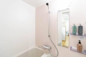 a bathroom with a shower and a bath tub at 櫻の宿 Sakura Osaka Midoribashi5min 3ppl liubj7 in Osaka