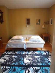 twee bedden in een kamer met een tapijt bij Ugglebo, stuga in Nauvo