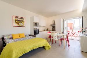 a bedroom with a bed and a table and a kitchen at La Casa di Venere with parking in Bari