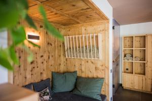 a living room with a couch and a wooden wall at Chalet Ortles M in San Valentino alla Muta