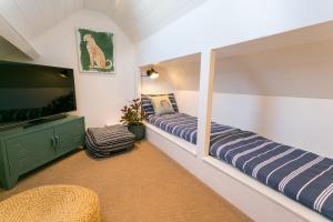 a room with two beds and a flat screen tv at Treforris in Rhosneigr