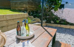 un grupo de botellas de vino sentadas en una mesa de madera en Treforris, en Rhosneigr