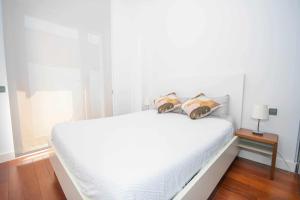 - un lit blanc avec 2 oreillers dans l'établissement Chueca Gran Via Recoletos Libertad 24 2, à Madrid