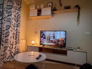 sala de estar con TV de pantalla plana en la pared en Apartamento a 50 m de Playa-Jardín. Boiro, en Boiro