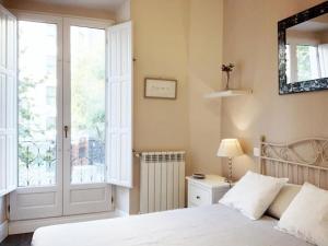 1 dormitorio con cama, ventana y puerta en Apartamento en Atocha Madrid Centro AVE muy grande, en Madrid