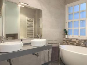 a bathroom with two sinks and a large mirror at Apartamento en Atocha Madrid Centro AVE muy grande in Madrid