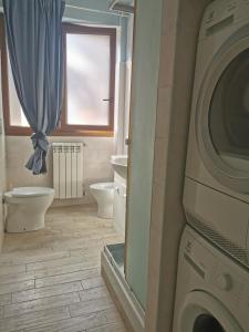 y baño con aseo y lavadora. en Home Brigitte en Frascati