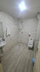 a bathroom with a toilet and a sink at Hotel Darda in Kamëz