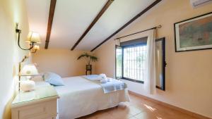 une chambre avec un lit blanc et une fenêtre dans l'établissement Alojamiento Rural la Aragonesa Marmolejo by Ruralidays, à Marmolejo 23 autres photos
