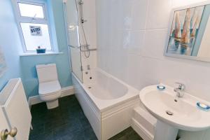 a bathroom with a sink and a tub and a toilet at Seaforth in Rhosneigr +10 photos