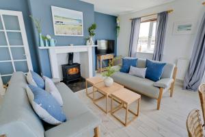 a living room with a couch and a fireplace at Ty Glan Y Mor in Aberffraw