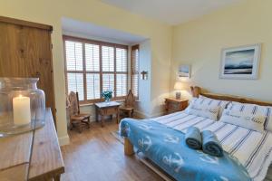 a bedroom with a bed and a table with a candle at Seaforth in Rhosneigr