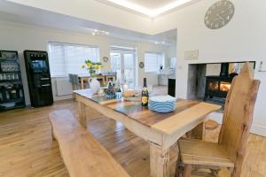 a dining room with a table and chairs and a fireplace at Seaforth in Rhosneigr
