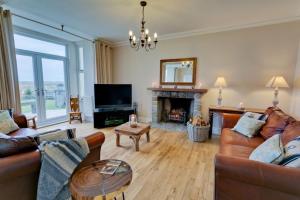 a living room with a couch and a fireplace at Seaforth in Rhosneigr
