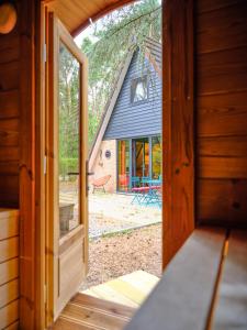 an open door of a cabin with a view of a yard at Boshuisje Pinus in Lanaken