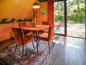 a dining room with a wooden table and chairs at Boshuisje Pinus Sonnevijver Residences in Lanaken