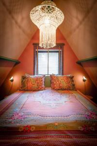 a bedroom with a large bed with a chandelier at Boshuisje Pinus in Lanaken