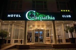 a hotel with a neon sign in front of a building at Hotel Carpathia in Sinaia