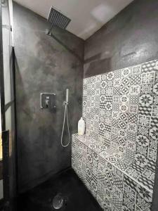 y baño con ducha con azulejos blancos en la pared. en Les Suites du Palais, en Carcassonne