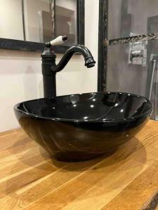 um lavatório preto com uma torneira na casa de banho em Les Suites du Palais em Carcassonne