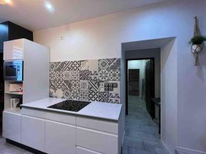 uma cozinha com armários brancos e um fogão com forno em Les Suites du Palais em Carcassonne mais 5 fotografias