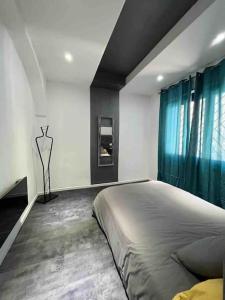 1 dormitorio con 1 cama grande y cortinas azules en Les Suites du Palais en Carcasona