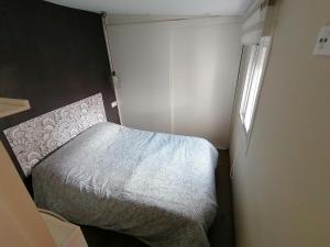 ein kleines Schlafzimmer mit einem Bett und einem Fenster in der Unterkunft Planta baja de casa con patio in Vigo