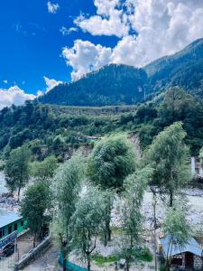 vistas a un río con árboles y montañas en Aadarsh Hotel, Nanital, en Nainital