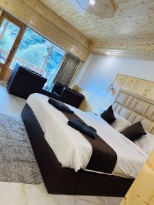 1 dormitorio con 2 camas en una habitación con ventanas en Aadarsh Hotel, Nanital, en Nainital