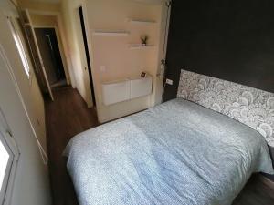 ein kleines Schlafzimmer mit einem Bett mit einer blauen Decke in der Unterkunft Planta baja de casa con patio in Vigo