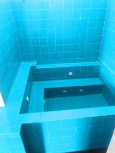 - une baignoire carrelée de bleu avec du carrelage bleu dans l'établissement Villa Cinnamon Nature, à Beruwala