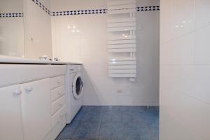 a white bathroom with a washing machine in it at Arcachon pied in Arcachon +2 photos