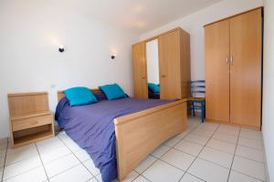 a bedroom with a large bed with blue pillows at Arcachon pied in Arcachon
