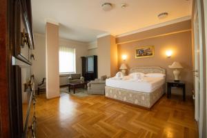 Hotel Home Story Sarajevo, Vogošća في فوغوشتشا: غرفة نوم مع سرير وغرفة معيشة