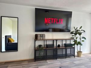 a living room with a tv on a wall with a mirror at Zentrales Apartment am Theater in Marl in Marl