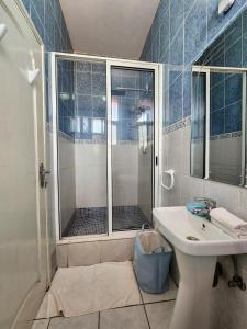 uma casa de banho com um chuveiro, um lavatório e um chuveiro em La Casa Moz em Maputo