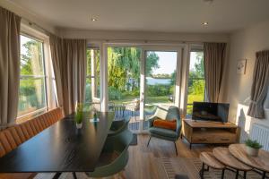 a living room with a table and a large window at Ferienhäuser Seepark Ternsche in Selm