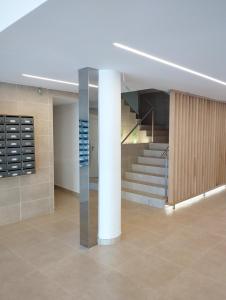 a lobby with a staircase and a pillar in a building at R&G Pineda Apartamento in La Pineda