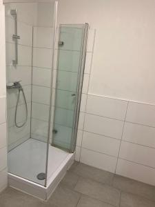 una ducha con puerta de cristal en un baño en Boarding House Hagen, en Hagen