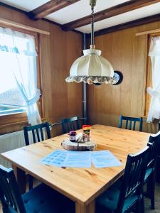 einen Holztisch mit Stühlen und einer Leuchte in der Unterkunft Chalet Waldwiese - CharmingStay in Flumserberg