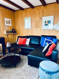 sala de estar con sofá de cuero negro en Chalet Waldwiese - CharmingStay, en Flumserberg