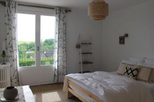 a bedroom with a bed and a sliding glass door at Au 19 in Tanlay