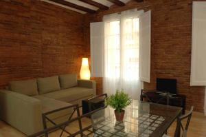 sala de estar con sofá y mesa de cristal en Gothic - Ramblas Apartments, en Barcelona