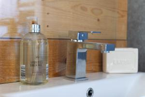 a soap bottle sitting on a sink next to a faucet at Willow Cottage in Gaerwen +75 photos